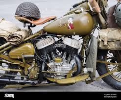 US army vintage Harley Davidson motorbikes take part in a road parade near D-Day landing beaches